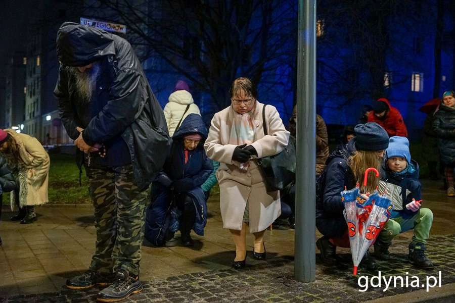 Ludzie idą ulicami miasta w czasie drogi krzyżowej.