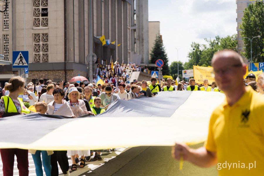 Uczestnicy zjazdu ze stumetrową flagą kaszubską podczas przemarszu