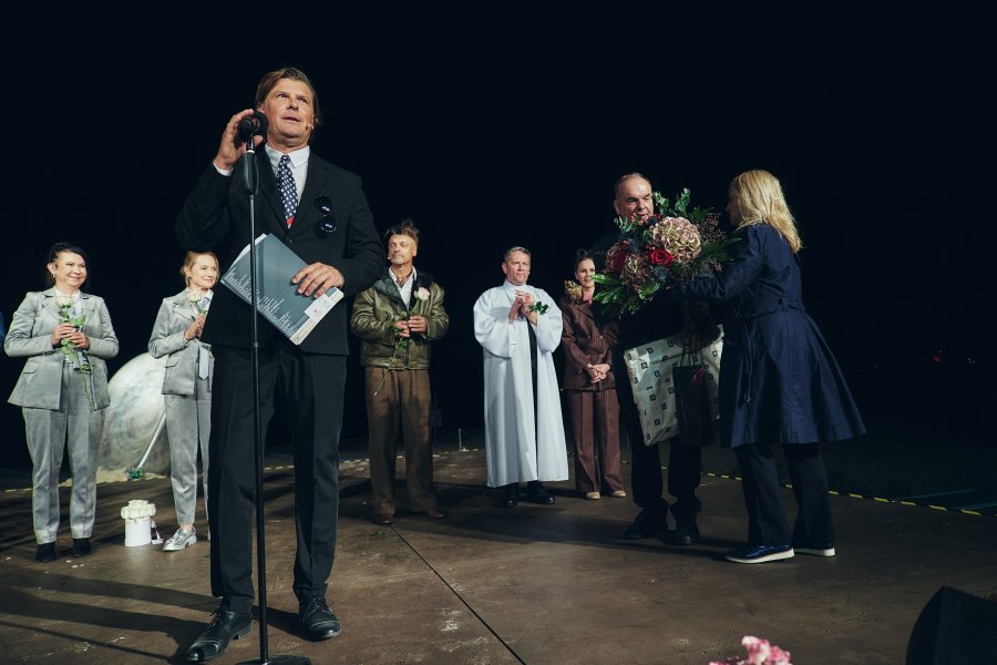 Kobieta wręcza mężczyźnie wiązankę kwiatów 