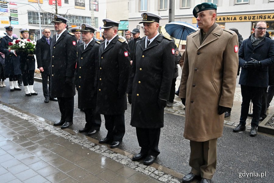 Marynarze Marynarki Wojennej i żołnierz stoją w szeregu.