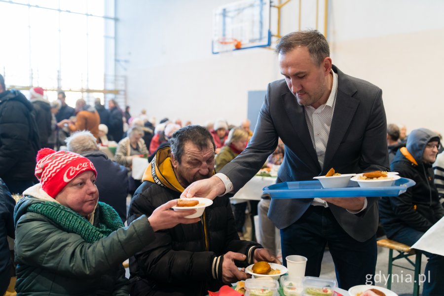 Wiceprezydent Tomasz Augustyniak roznoszący świąteczne potrawy gościom wigilii dla samotnych i potrzebujących 