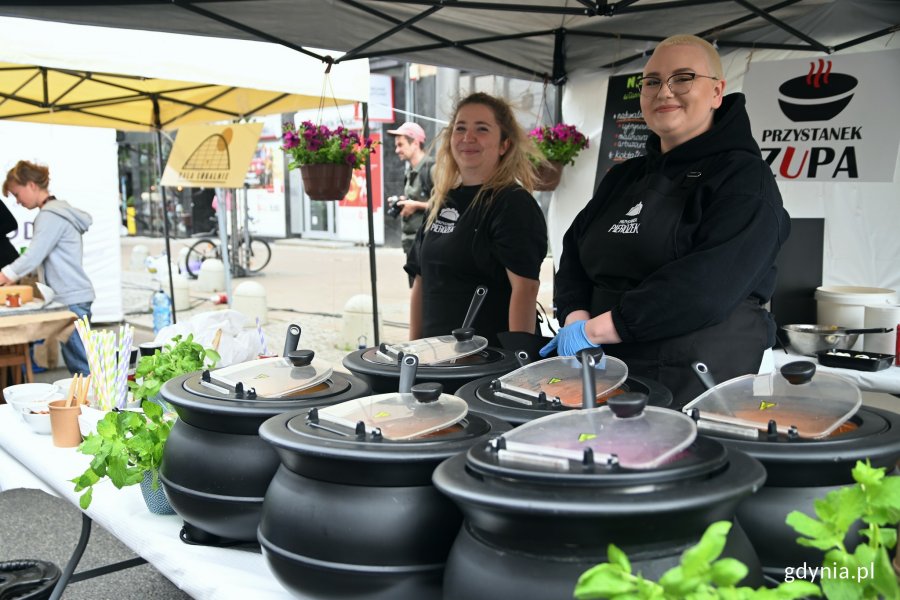 Stoisko restauracji „Przystanek zupa” na 5. edycji festiwalu „Kulinarna Świętojańska”. Na pierwszym planie naczynia z róznymi rodzajami zup. Za stołem stoją dwie uśmiechnięte restauratorki // fot. Magdalena Czernek