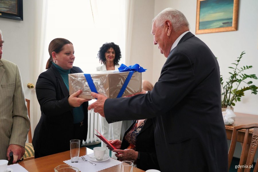 Kobieta podaje mężczyźnie prezent