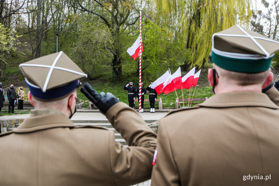 Na pierwszym planie salutujący żołnierze, na drugim planie marynarze wciągają na maszt flagę państwową z okazji Święta Konstytucji 3 Maja // fot. Karol Stańczak