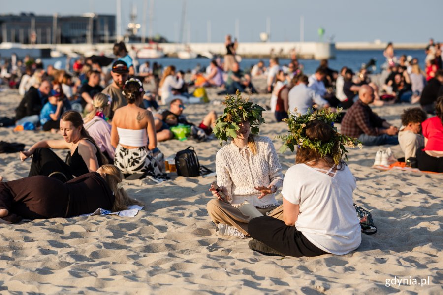 Ludzie siedzą w wiankach na plaży