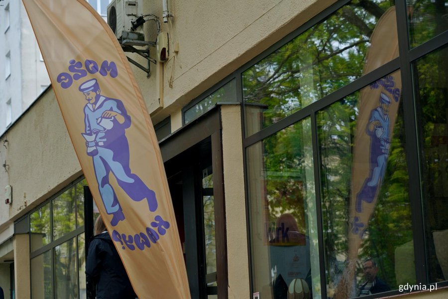 Flyer z logo Może Kawy? stojący przed kawiarnią 