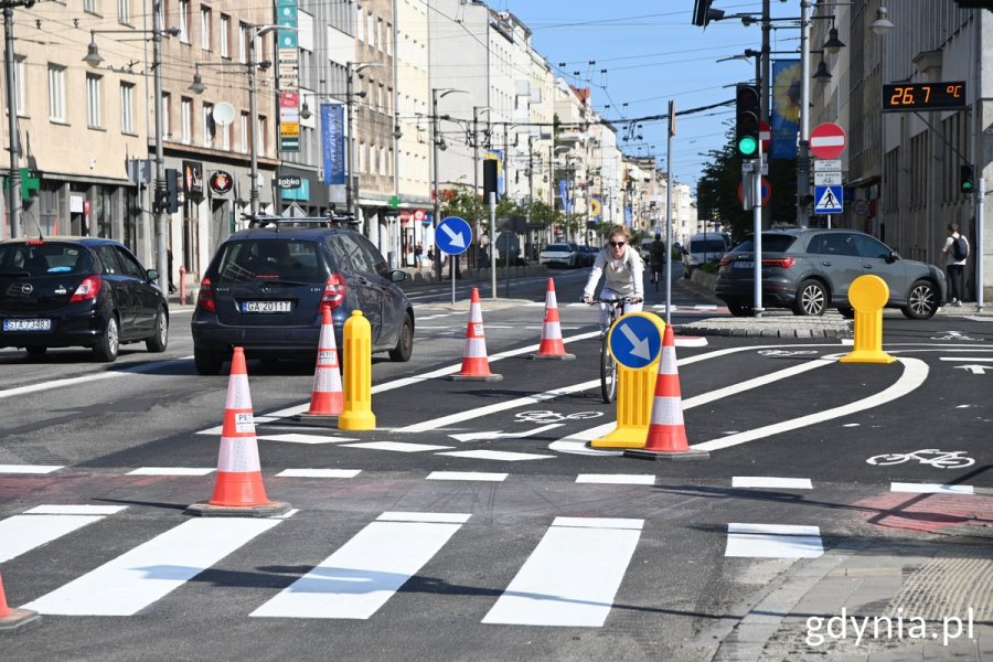 Ruch uliczny: samochody i rowerzystka kieruje się w stronę Wzgórza św. Maksymiliana