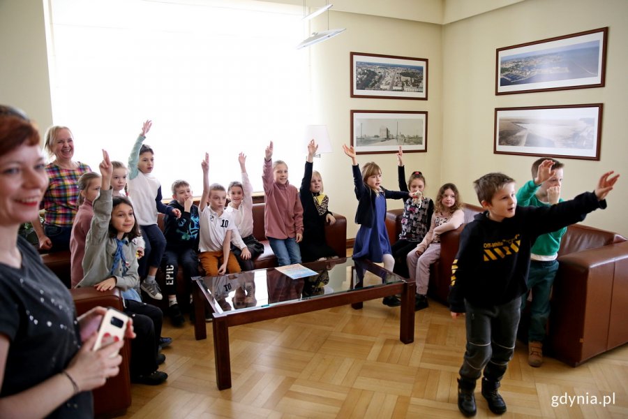 Uczniowie Szkoły Podstawowej nr 23 oraz ich opiekunowie w gabinecie prezydenta Gdyni podczas wizyty w Urzędzie Miasta. Uczniowie mają uniesione ręce // fot. Przemysław Kozłowski