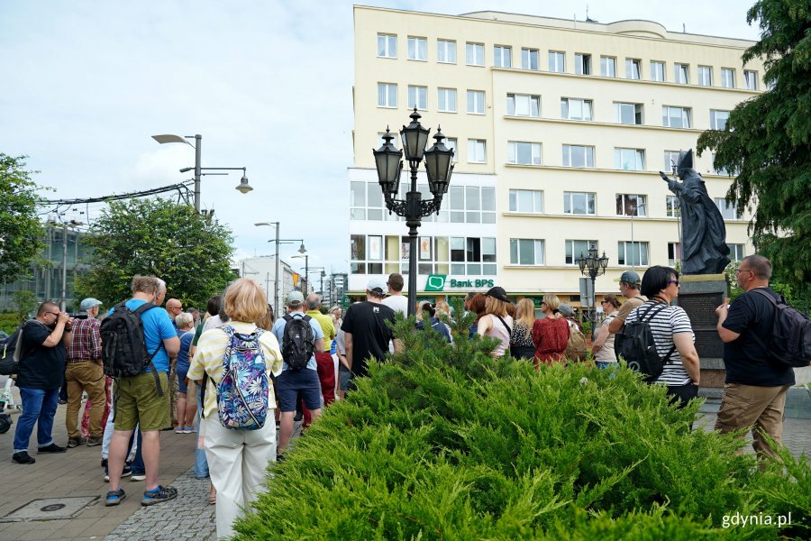 Uczestnicy spaceru architektonicznego szlakiem modernizmu przyglądający się kamienicy Józefa Skwiercza