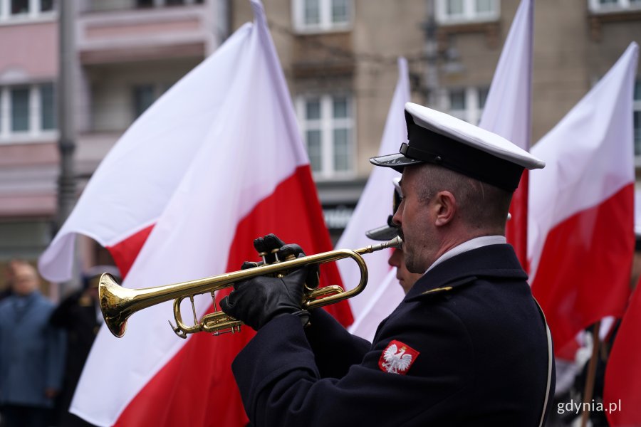 marynarz w stroju galowym gra na trąbce