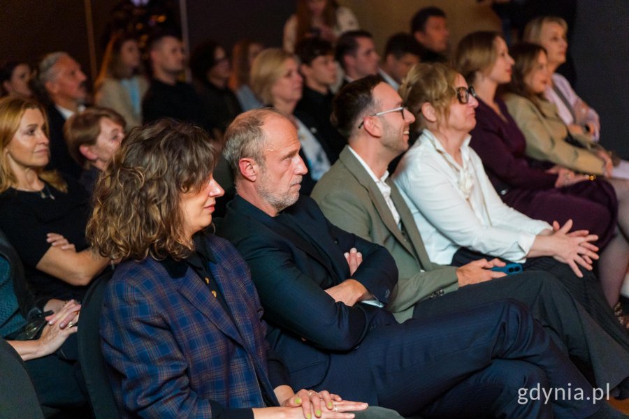 Kobiety i mężczyźni na widowni, podczas wręczenia nagr&oacute;d Pulsary. Na zdjęciu m.in. Łukasz Simlat, aktor filmowy i teatralny