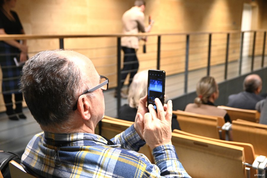 Mężczyzna filmuje wystąpienie telefonem