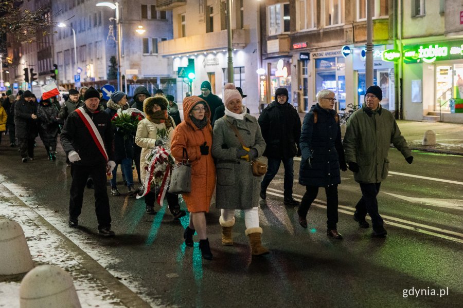 Ludzie w odświętnych strojach idący ulicą