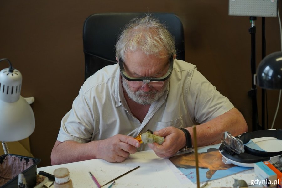 Reżyser Marek Skrobecki pochylony nad biurkiem