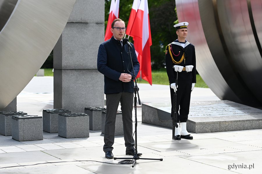 Jakubu Ubych - wiceprzewodniczący Rady Miasta Gdyni wygłosił przemówienie podczas uroczystości z okazji Dnia Weterana Działań poza Granicami Państwa oraz Międzynarodowego Dnia Uczestników Misji Pokojowych ONZ. Za nim: fragment pomnika Polski Morskiej i żołnierz z posterunku honorowego // fot. Michał Puszczewicz