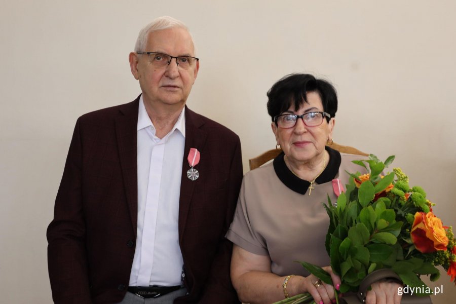 Para, mężczyzna z medalem, kobieta z bukietem kwiat&oacute;w