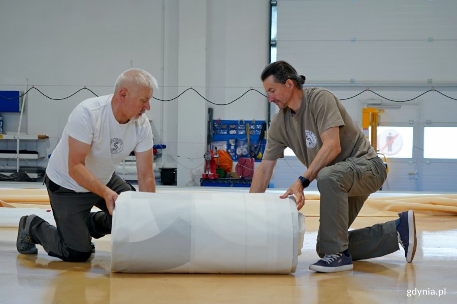 Pracownicy firmy Sail Service składający żagiel stulecia Gdyni 