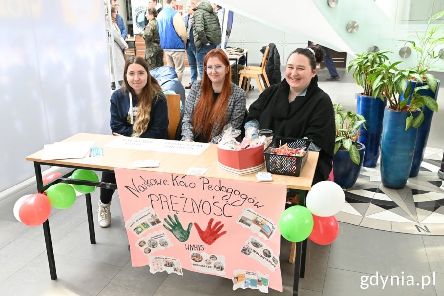 Stoisko Naukowe Koło Pedagogów z trzema studentkami