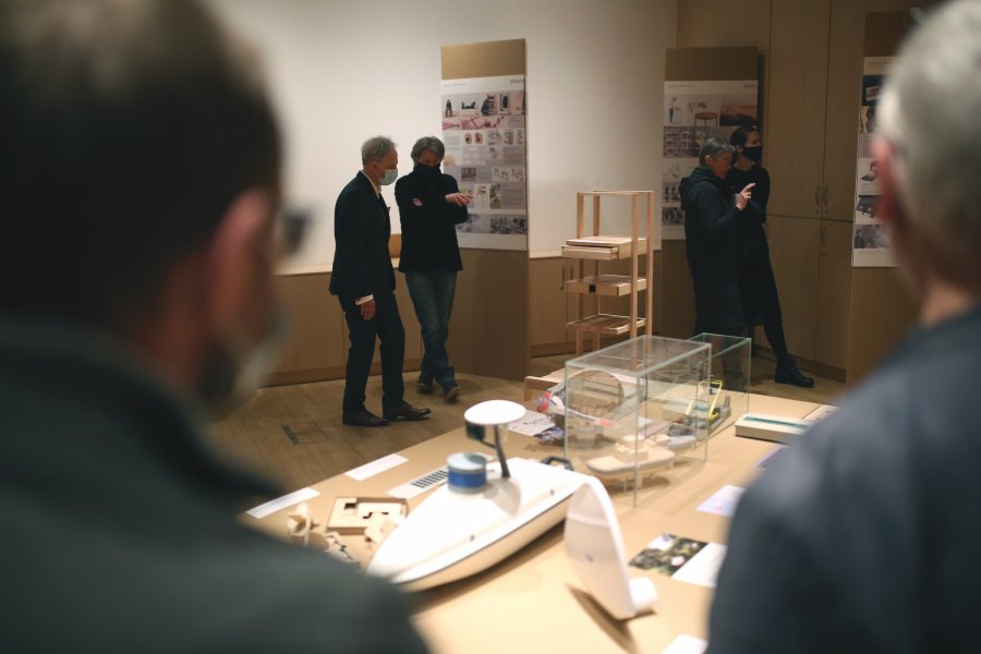 Zwiedzający oglądający eksponaty na wystawie „Zbiory 1964-2021” w Muzeum miasta Gdyni. Stoją przy stolikach oraz planszach ze zdjęciami // fot. T.Kwiatkowski