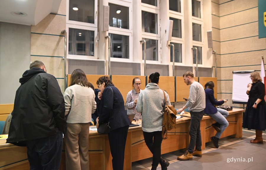 na zdjęciu ludzie rozmawiający przy biurku