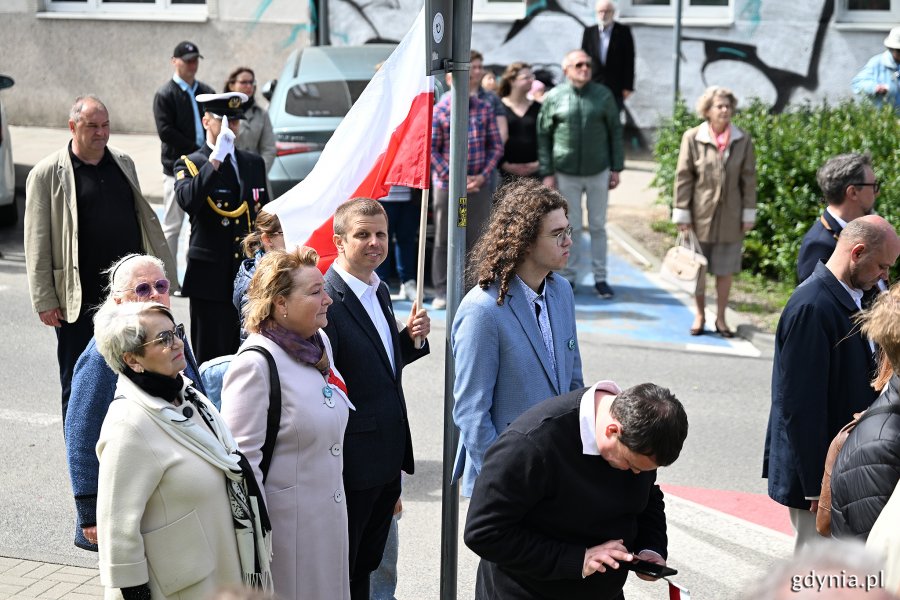 Uczestnicy uroczystości z okazji Święta Narodowego Trzeciego Maja. Jeden z nich trzyma w ręku biało-czerwoną flagę