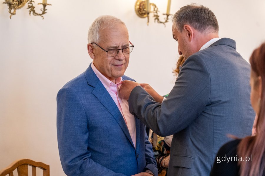 Dwóch mężczyzn, jeden przypina medal