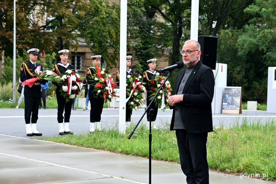 Michał Guć, wiceprezydent Gdyni ds. innowacji, podczas uroczystości z okazji 79. rocznicy wybuchu powstania warszawskiego. W tle zieleń i żołnierze MW trzymający w rękach wieńce i wiązanki kwiatów // fot. Magdalena Czernek
