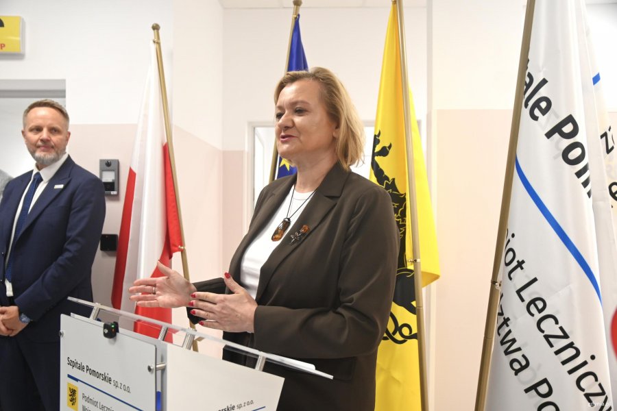 Kobieta w brązowej marynarce z mikrofonem