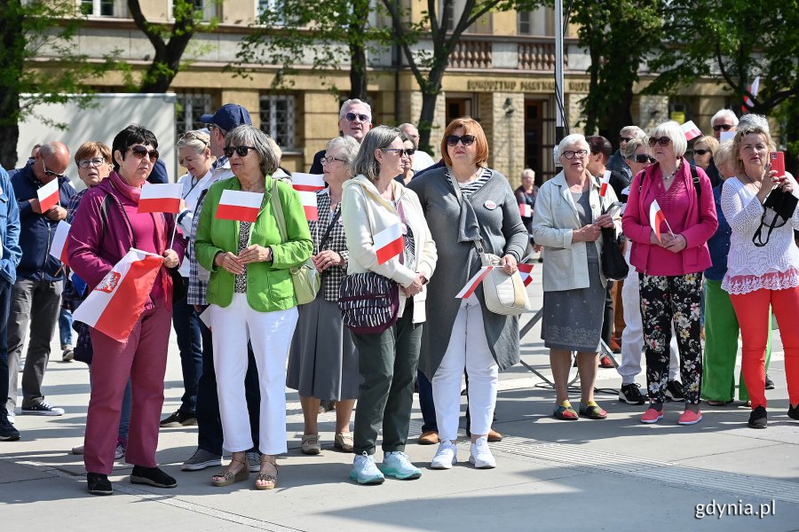 Mieszkańcy z biało-czerwonymi chorągiewkami na skwerze Kościuszki