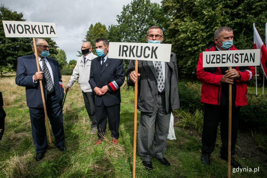 Uczestnicy uroczystości z okazji Dnia Sybiraka z białymi tabliczkami w rękach, na których napisano miejsca zsyłek Polaków: Workuta, Irkuck, Uzbekistan // fot. Karol Stańczak 