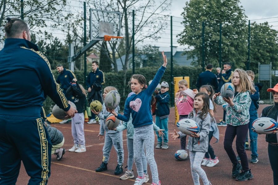 Dzieci z piłką do rugby na boisku