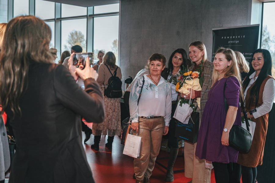 Agnieszka Cegielska pozuje do zdjęcia z innymi uczestnikami spotkania 