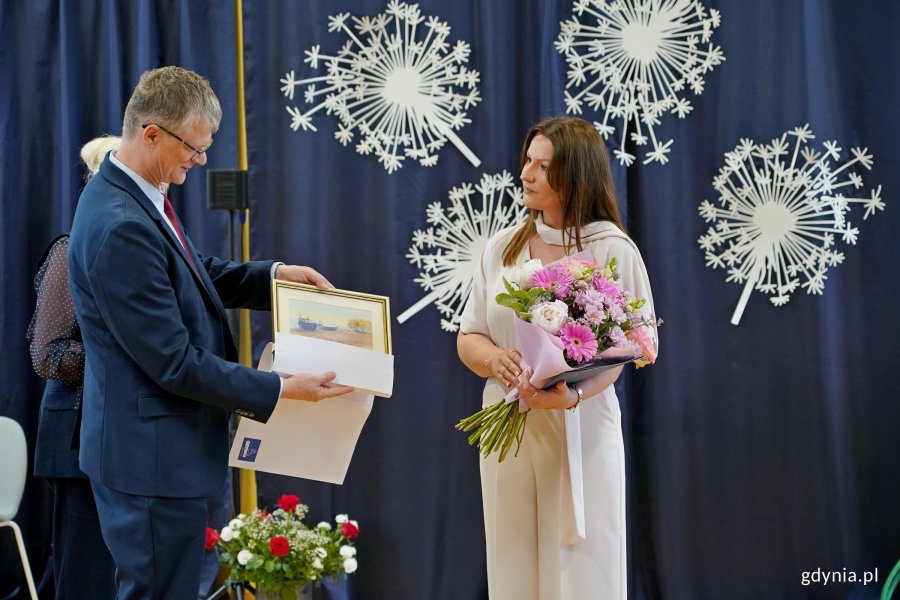 Wiceprezydent Gdyni Rafał Geremek wręczający pamiątkową akwarelę Joannie Zarzyckiej &ndash; dyrektorce Szkoły Podstawowej nr 11 