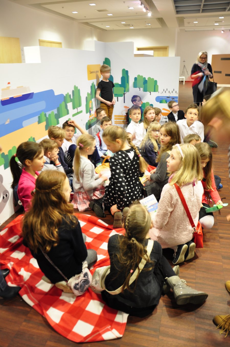 Dzieci siedzą na kocach piknikowych