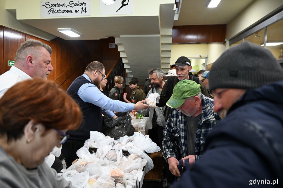 Wychodzący odbierają paczki z żywnością