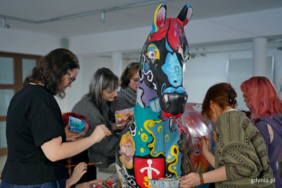 Uczniowie Państwowego Liceum Sztuk Plastycznych w Gdyni malujący rzeźbę konia, kt&oacute;rą miasto przekaże na licytację WOŚP 