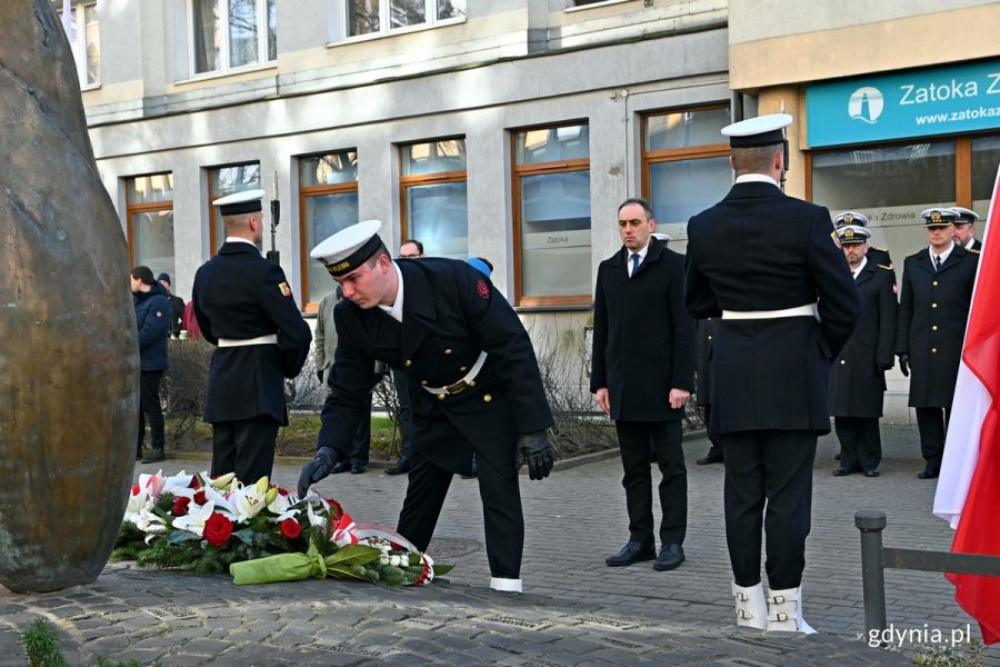 Na pierwszym planie marynarz nachylony nad wiązankami kwiatów. Za nim: Grzegorz Kuleta - dyrektor biura senatorskiego Sławomira Rybickiego składa kwiaty przed pomnikiem Ofiar Terroru Komunistycznego z okazji Narodowego Dnia Pamięci Żołnierzy Wyklętych // fot. Magdalena Czernek