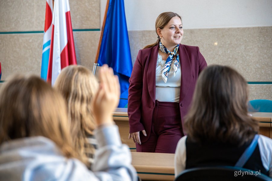 Prezydent miasta w wiśniowym garniturze i dzieci od tyłu