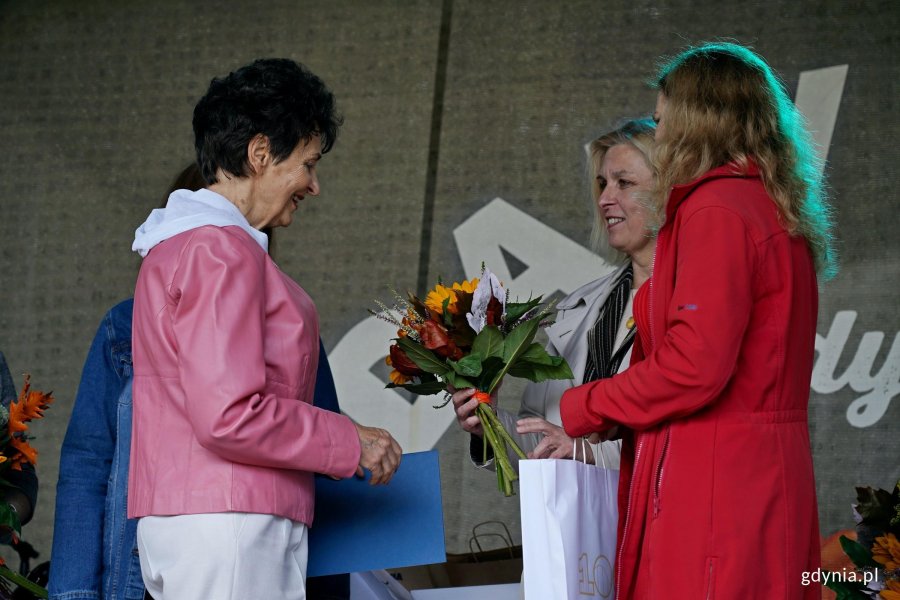 Beata Zastawna &ndash; przewodnicząca Rady Miasta Gdyni i Hanna Niedźwiecka-Pasternak &ndash; zastępca naczelnika Wydziału Ogrodnika Miasta wręczają nagrodę jednej z uczestniczek konkursu &bdquo;Gdynia w kwiatach&rdquo; 