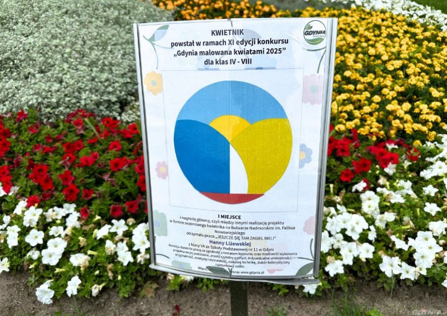 na zdjęciu tabliczka i kolorowa rabatka