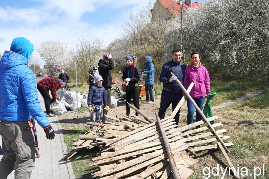 Ludzie w kurtkach i sterty śmieci