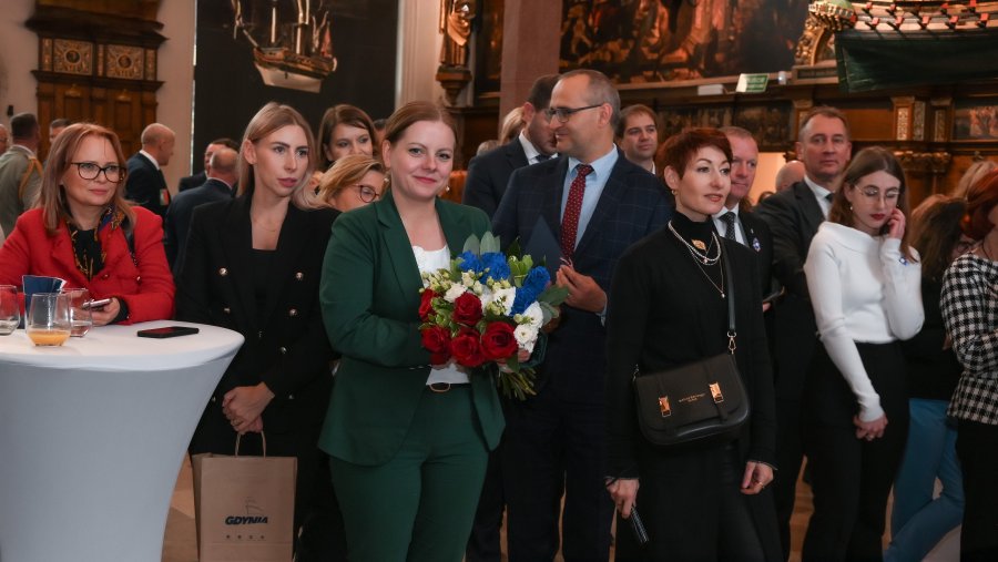 W Dworze Artusa stoją m.in.: wicewojewoda pomorski Emil Rojek, prezydent Gdyni Aleksandra Kosiorek i radna Gdyni – Anna Salomon