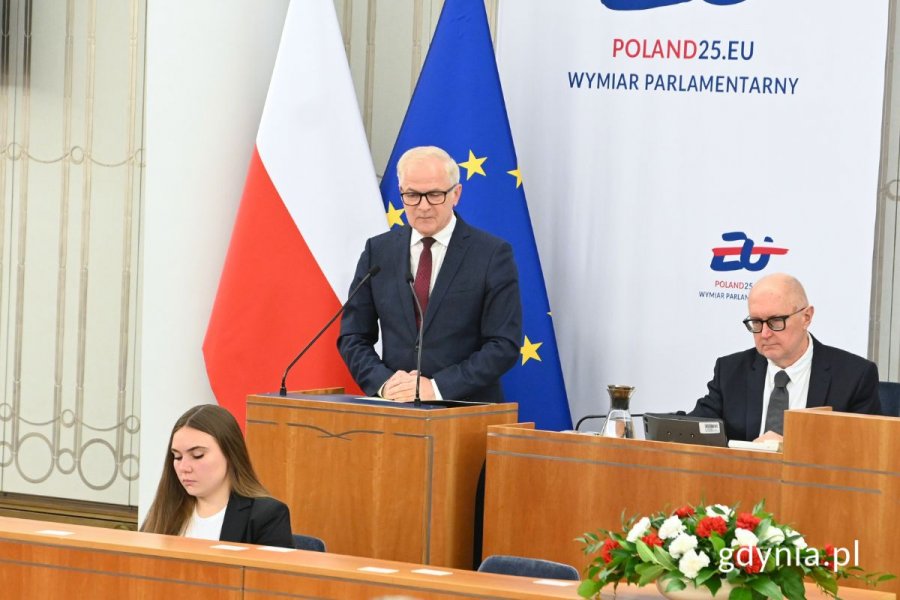 Senator Sławomir Rybicki stojący przy mównicy na sali obrad Senatu