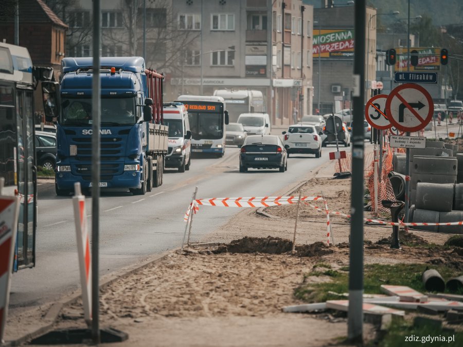 trwające roboty drogowe, widoczne elementy infrastruktury, oznakowanie, ruch uliczny