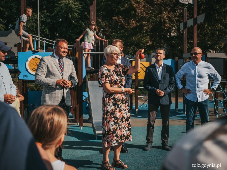 Na zdjęciu widoczna grupa osób podczas otwarcia wyremontowanego skweru, plac zabaw