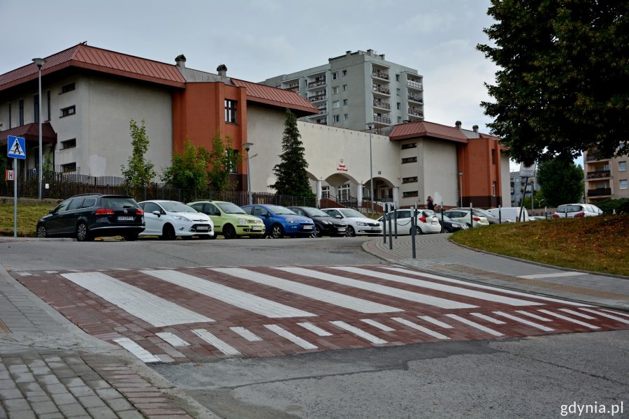 Wyniesione przejście dla pieszych, w tle zaparkowane auta oraz budynek szkoły przy ul. Chwaszczyńskiej // fot. gdynia.pl
