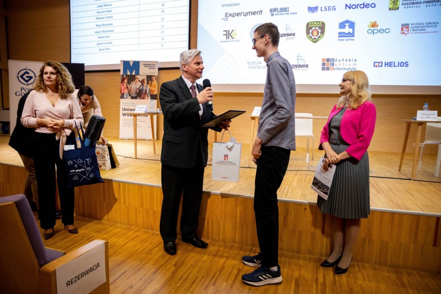 dr Cezary Tatarczuk, Pełnomocnik Rektora ds. Jakości Kształcenia Wyższej Szkoły Administracji i Biznesu im. Eugeniusza Kwiatkowskiego wręcza nagrodę finaliście konkursu/  fot. Uniwersytet WSB Merito Gdynia