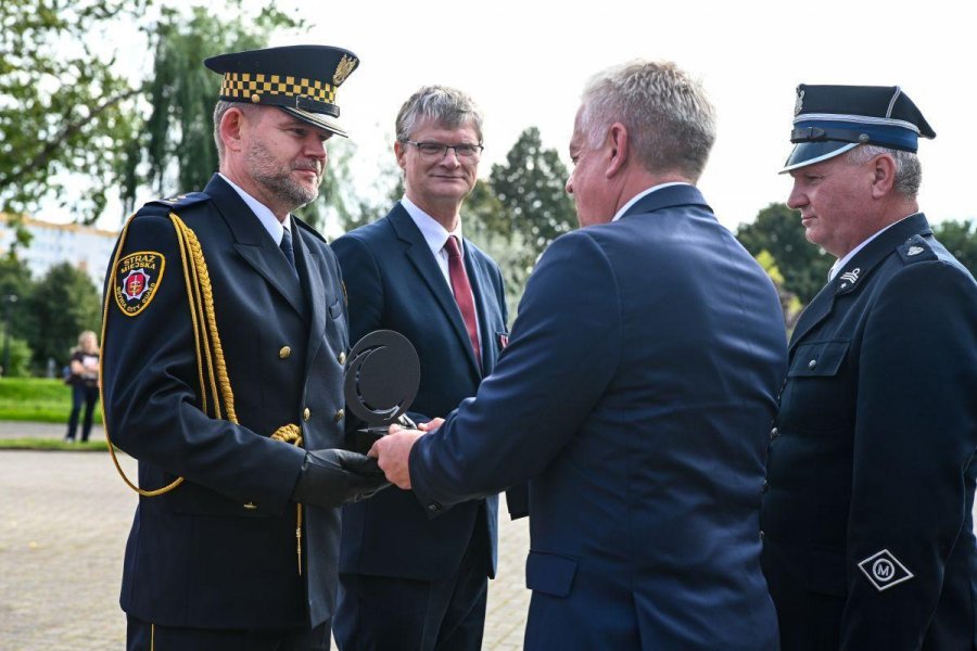 Komendant Wydziału Straży Miejskiej i Zarządzania Kryzysowego Urzędu Miasta Gdyni Robert Ronduda otrzymuje nagrodę z rąk prezesa Zarządu Gdyńskiej Komunikacji Miejskiej Tomasza Konewki 