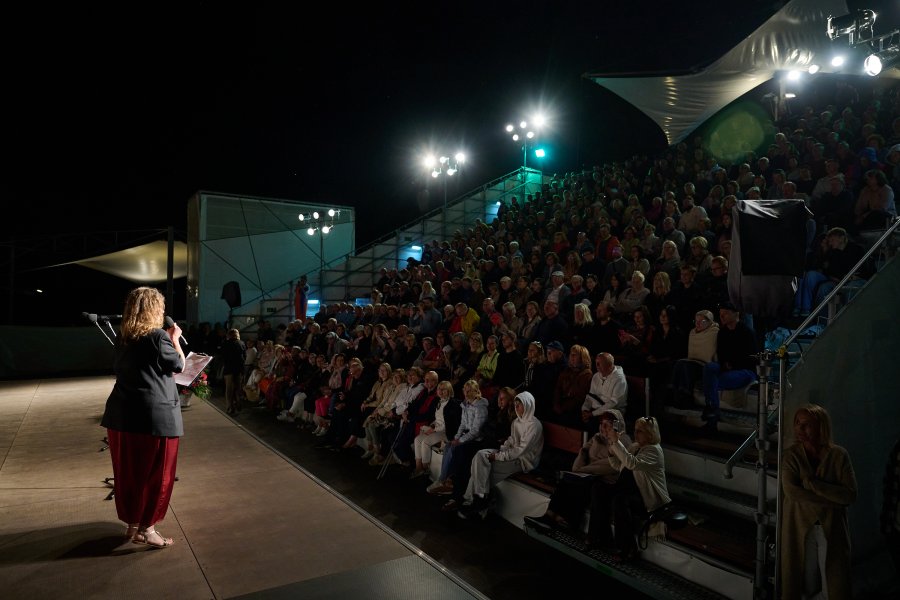 Widzowie i dyrektorka Teatru Miejskiego w Gdyni na Scenie Letniej po zmroku