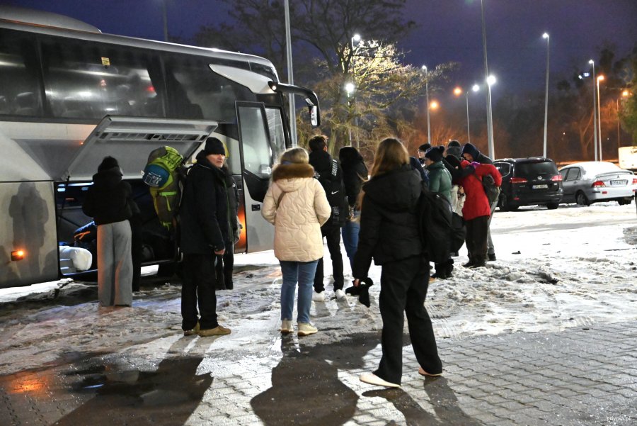 Ciepło ubrani ludzie przed autokarem